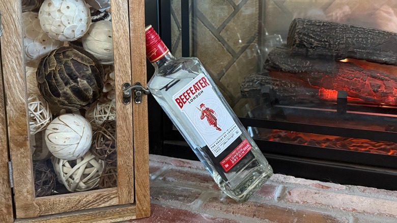 bottle of Beefeater laying against a fireplace