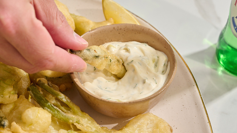 dipping fried asparagus into aioli