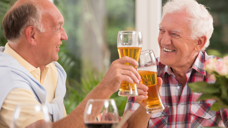 two older men drinking beer together