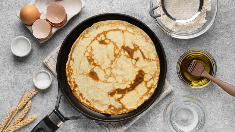 a crepe in a pan surrounded by ingredients