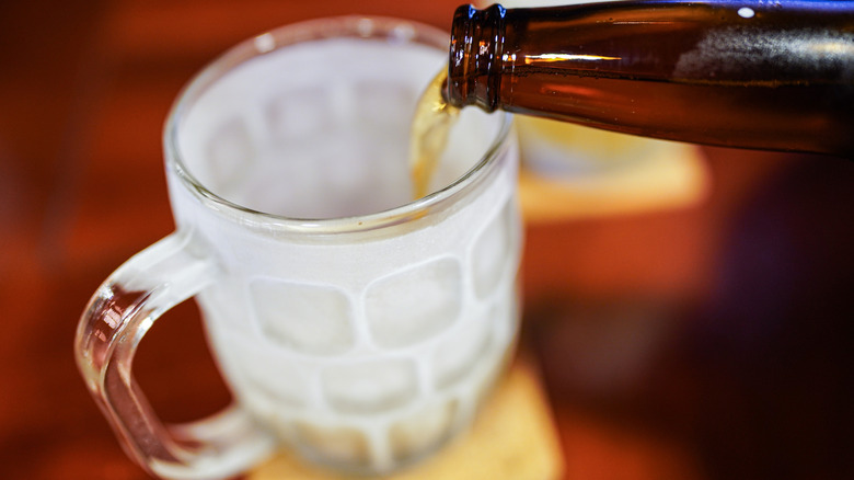Pouring beer from a bottle into a frosted glass