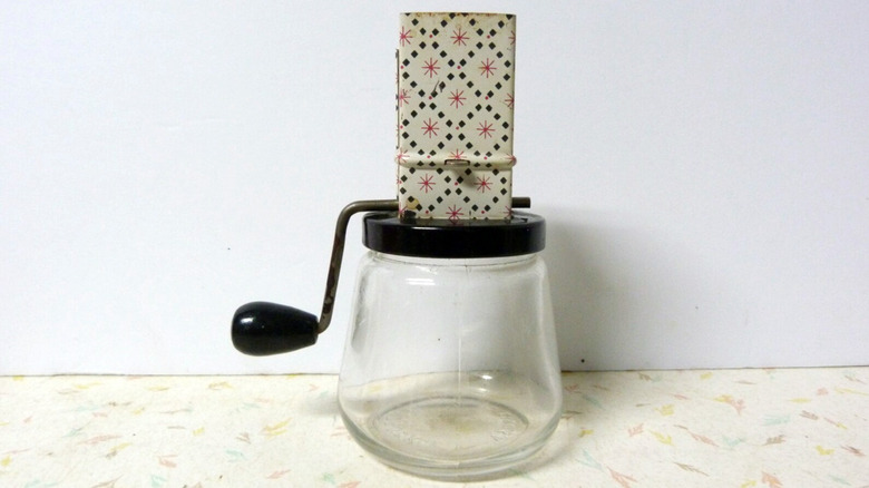 vintage nut grinder with metal hopper and glass container