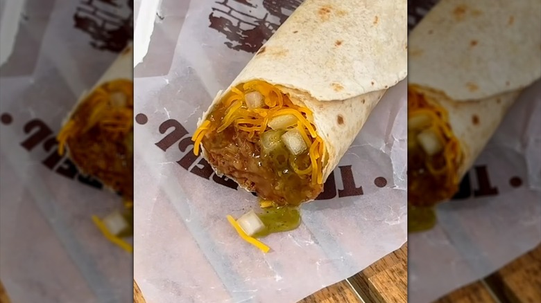 Close-up of a Taco Bell burrito with green sauce