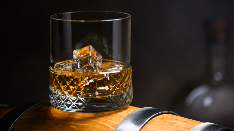 glass of bourbon on barrel