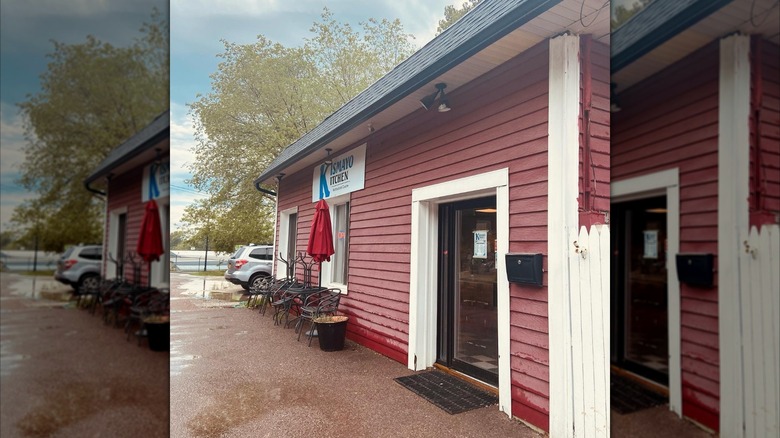 Kismayo Kitchen in Burlington, Vermont entrance with a sign, tables, and chairs