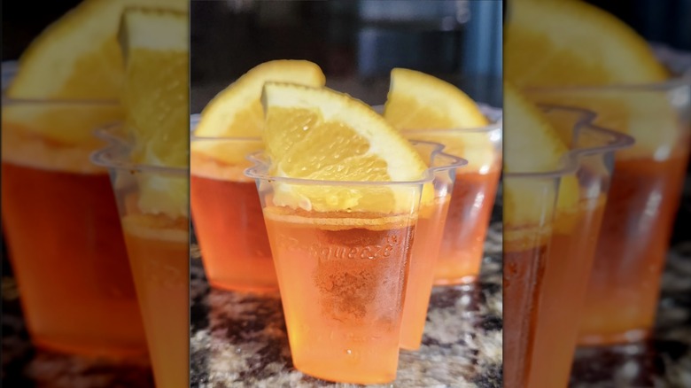 Three Aperol Spritz jello shots with lemon garnish