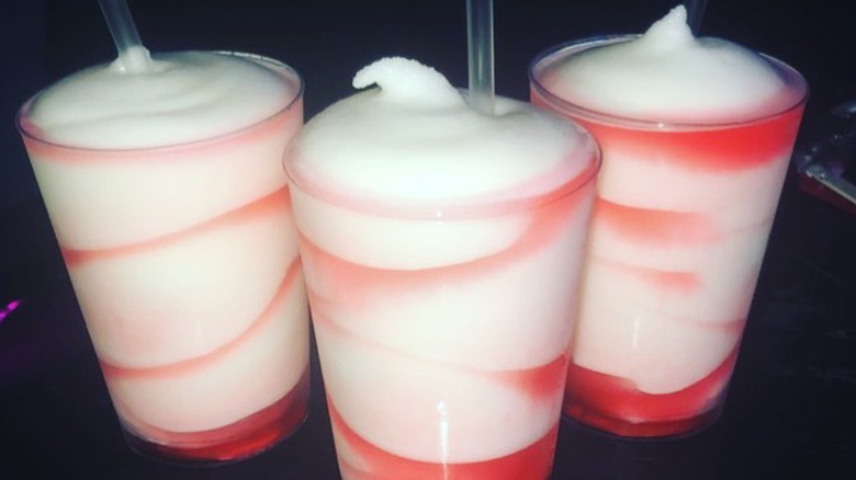 Three frozen drinks with strawberry on bar