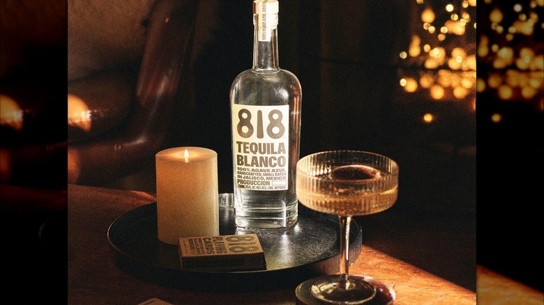 Bottle of 818 Blanco with cocktail glass and candle