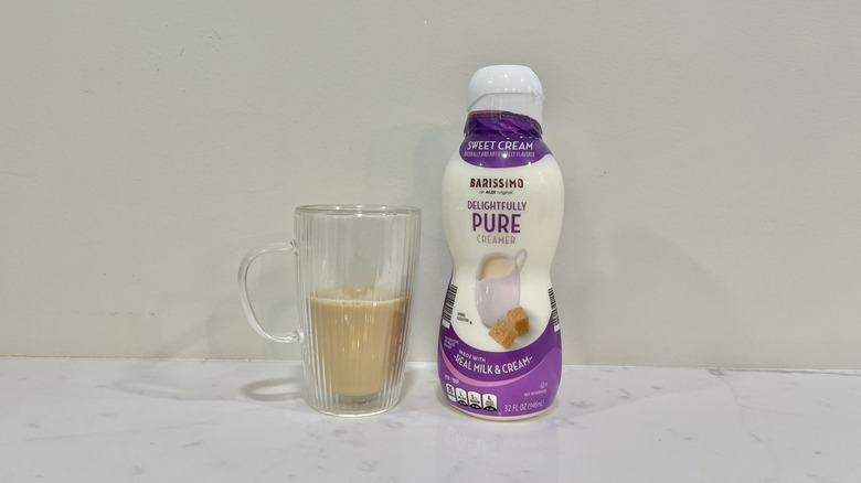 Aldi's barissimo delightfully pure coffee creamer next to a cup of coffee