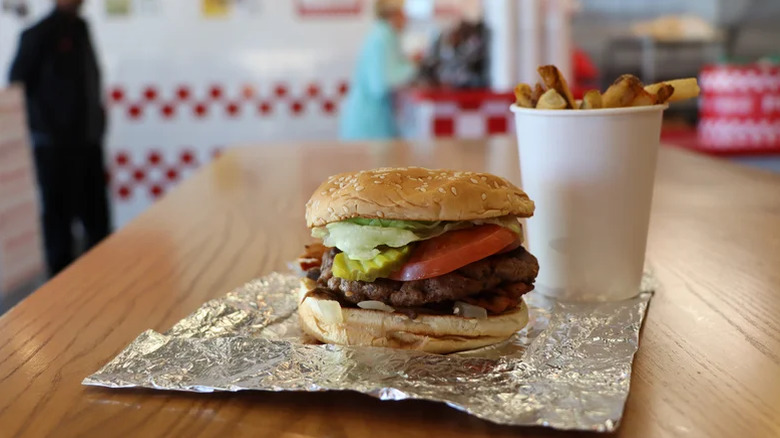 Five Guys burger beside a cup of hand-cut fries