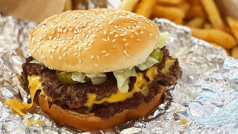 Five Guys burger with fries in the background