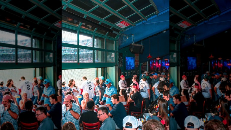 Bleacher Bar crowded looking out over Fenway Park
