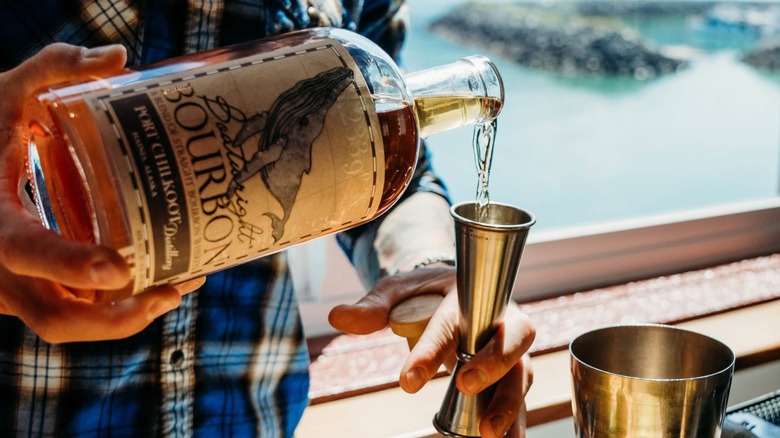 Person in flannel pouring bottle of Boatwright Bourbon