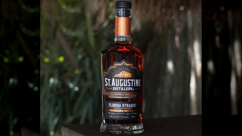 Bottle of St. Augustine Distillery Florida bourbon with greenery in background