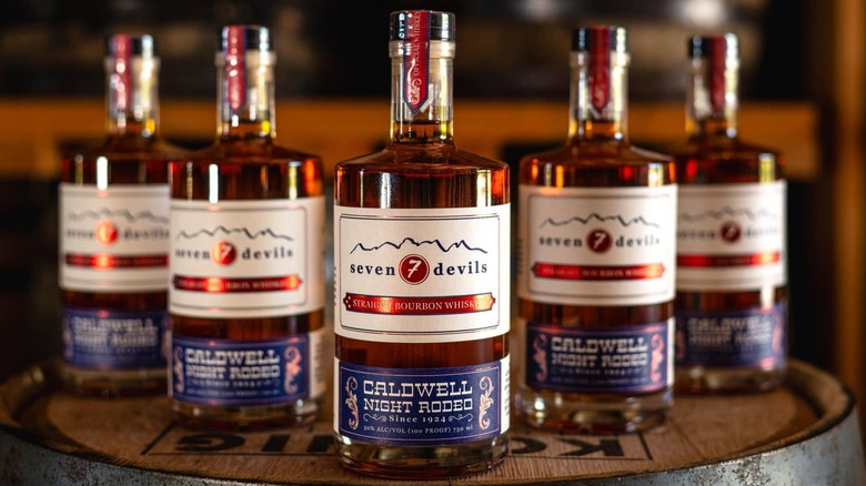 Five bottles of Seven Devils Night Rodeo bourbon on barrel