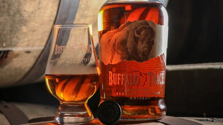 Bottle of Buffalo Trace with glass on barrels