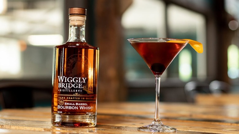 Bottle of Wiggly Bridge bourbon and cocktail on table