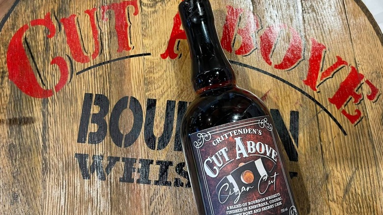 Bottle of Cut Above bourbon against barrel end