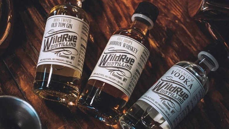 Three bottles of spirits from WildRye Distilling on wooden table