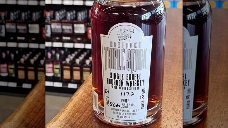 Bottle of bourbon with white label on counter at store
