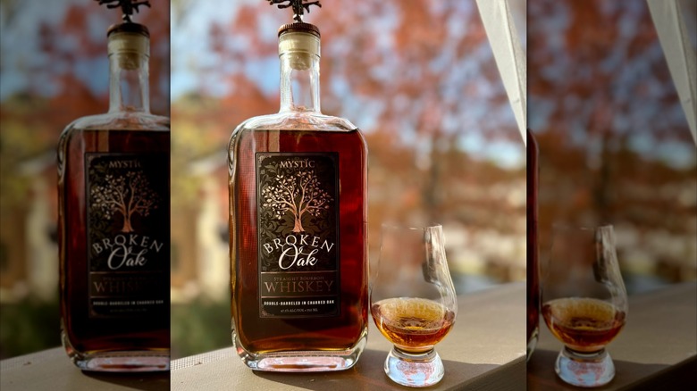 Bottle of Broken Oak whiskey and glass outside