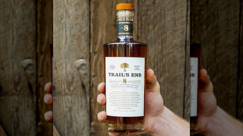 Hand holding bottle of Trail's End bourbon