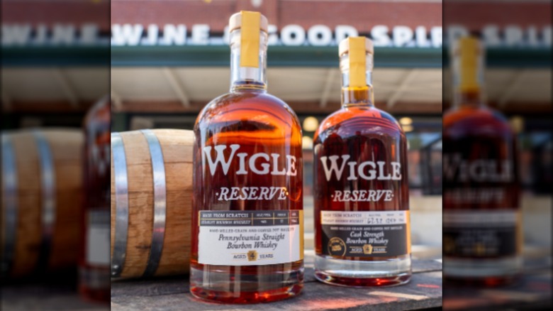 Two bottles of Wigle Reserve outside with blurred liquor store in background