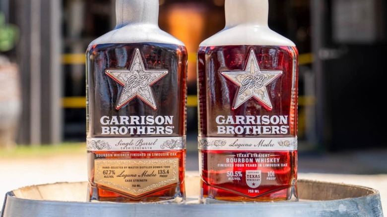 Two bottles of Garrison Brothers on barrel outside