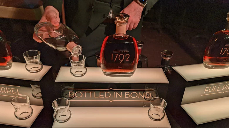 Person pouring 1792 bourbon bottle