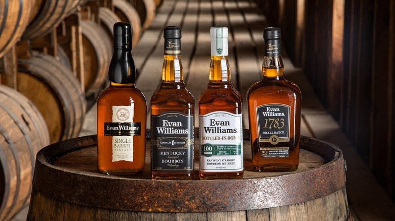 Evan Williams bourbon bottles lineup on top of a barrel
