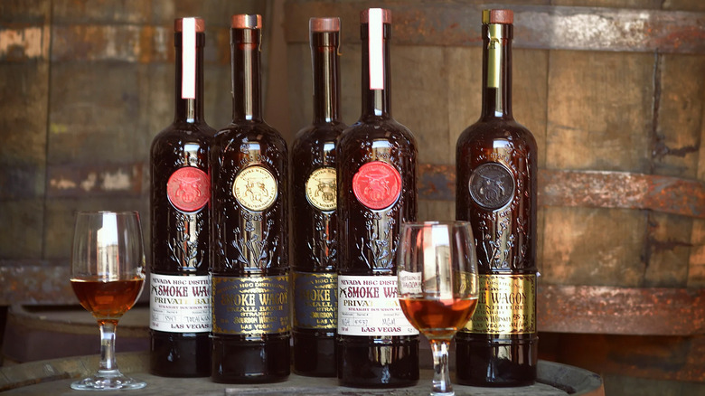 Smoke Wagon bourbon bottles lineup on a table with glasses