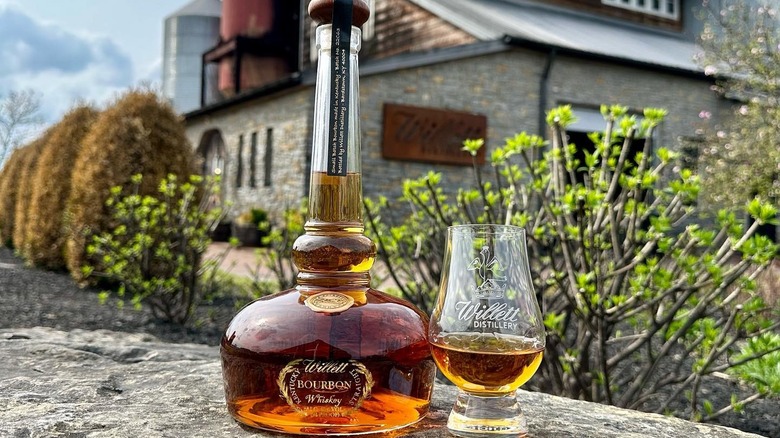 Willett bourbon bottle in front of Glencairn Distillery's exterior