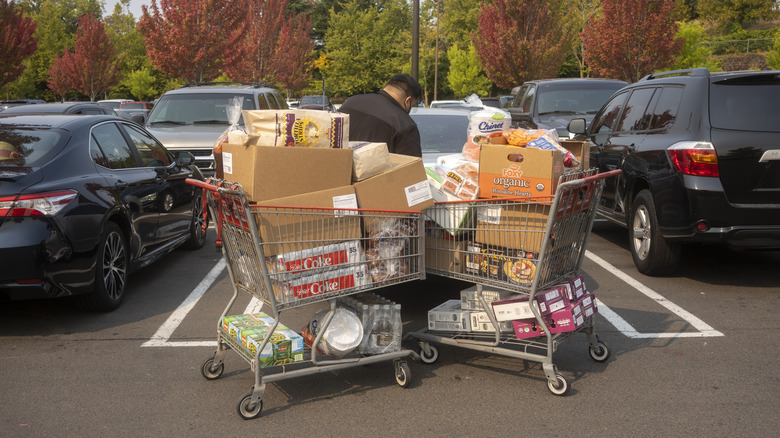 Two Costco carts with boxes holding groceries in a parking lot