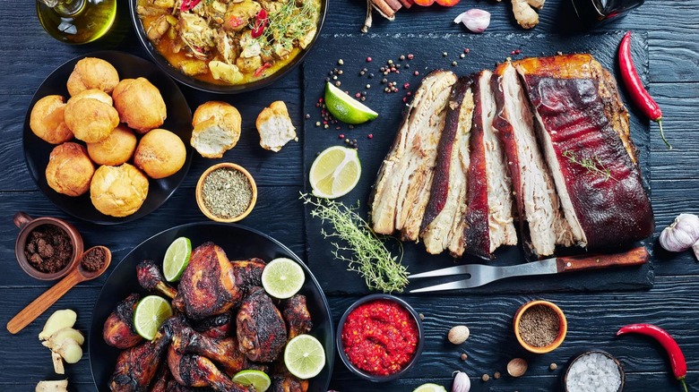 Assortment of meats, sides, and spices on a black table