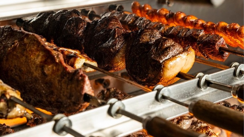 Skewers of assorted meats on steel racks