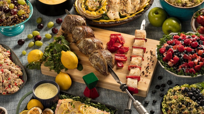 Assorted skewers and sides covering a table