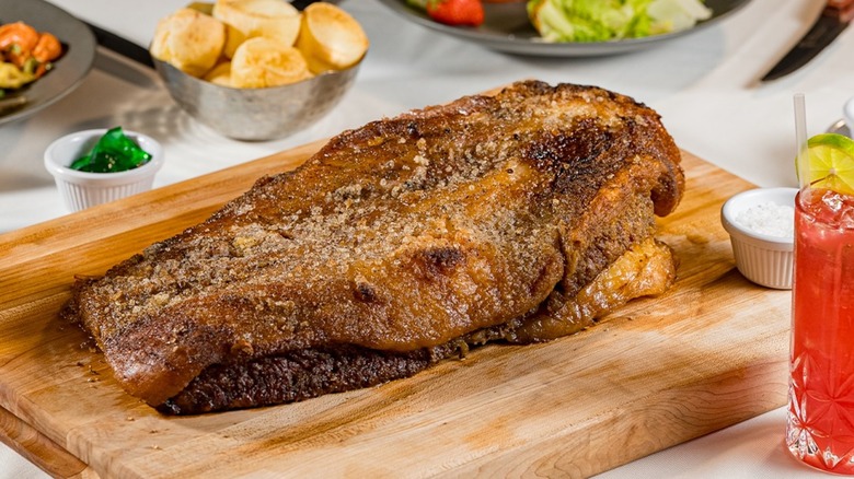 Brisket on a wooden board with sides on a table