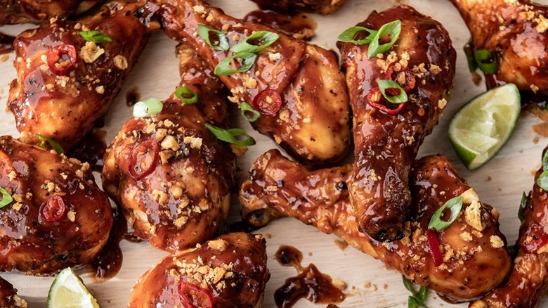 Spicy and saucy chicken legs with lime wedges