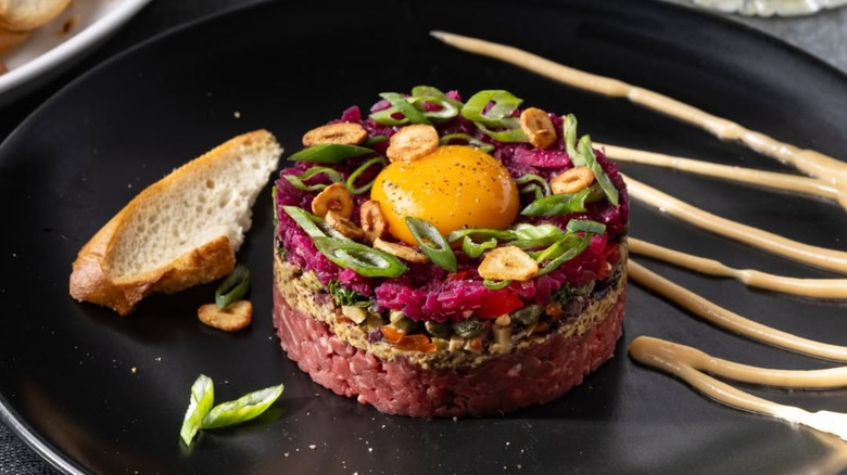 Picanha tartare on a plate with egg and bread