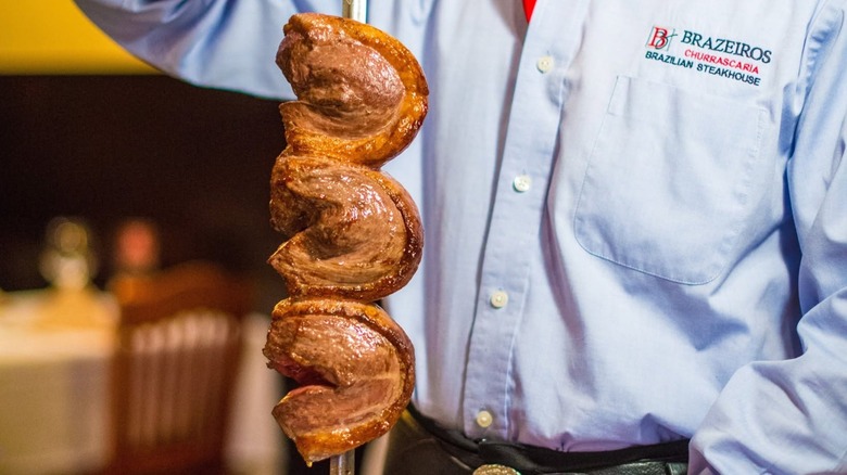 Meat skewer being held by a server