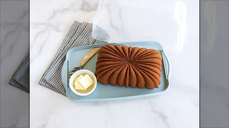 Nordic Ware Loaf Keeper with a cake and butter on a marble ounter