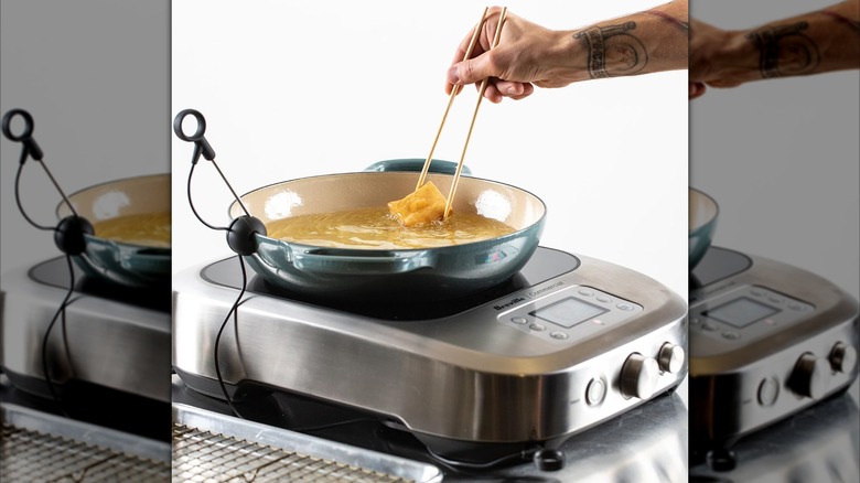 A person cooking on a Breville commercial Control Freak induction cooktop