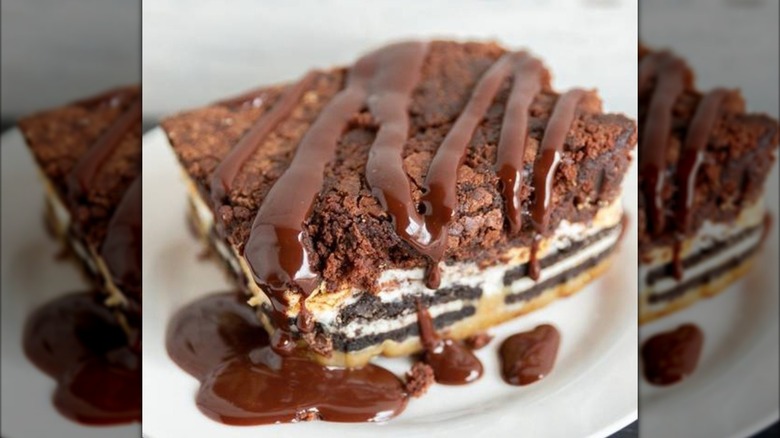 Close up of brownie with several layers and drizzled in chocolate
