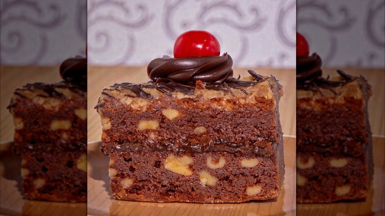 German chocolate brownie topped with chocolate frosting and cherry