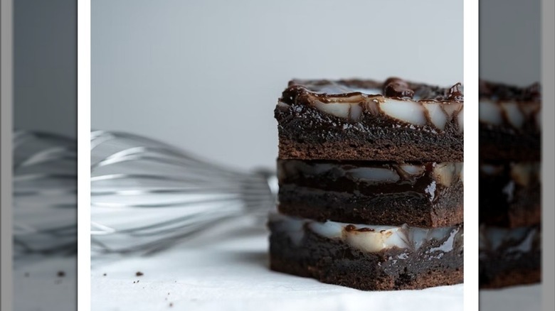 Three haupia chocolate chip brownies stacked with whisk in background