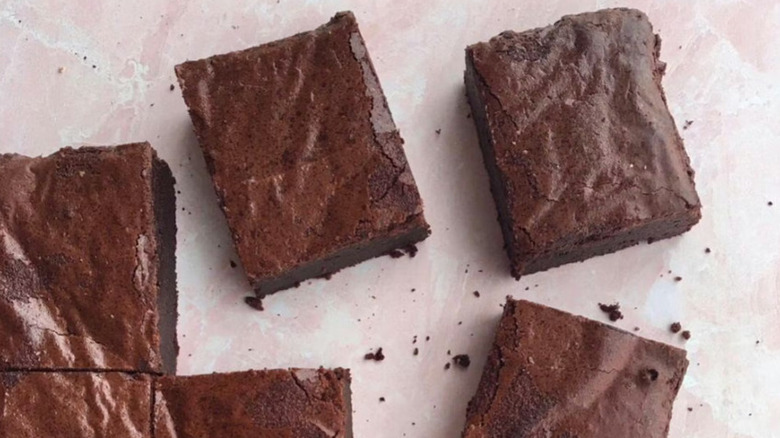 Top view of rectangular brownies with flaky crusts and crumbs scattered between