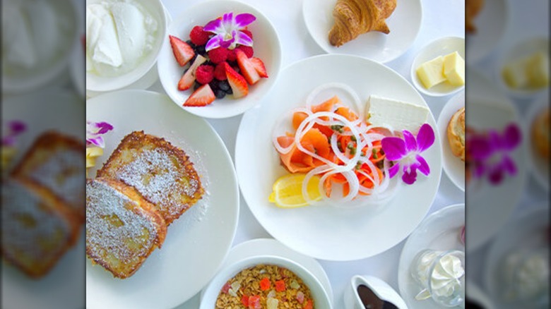 Assortment of brunch dishes on white plates and tablecloth