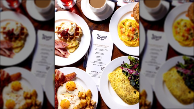 Assortment of brunch dishes on a table surrounding a menu