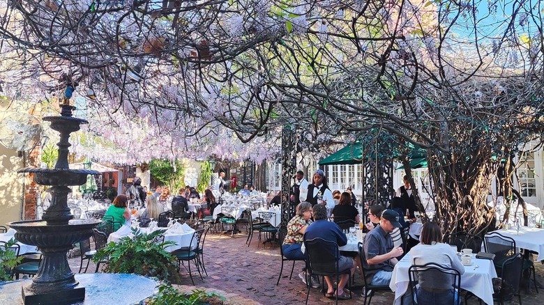 Diners eating on the outdoor patio of The Court of Two Sisters