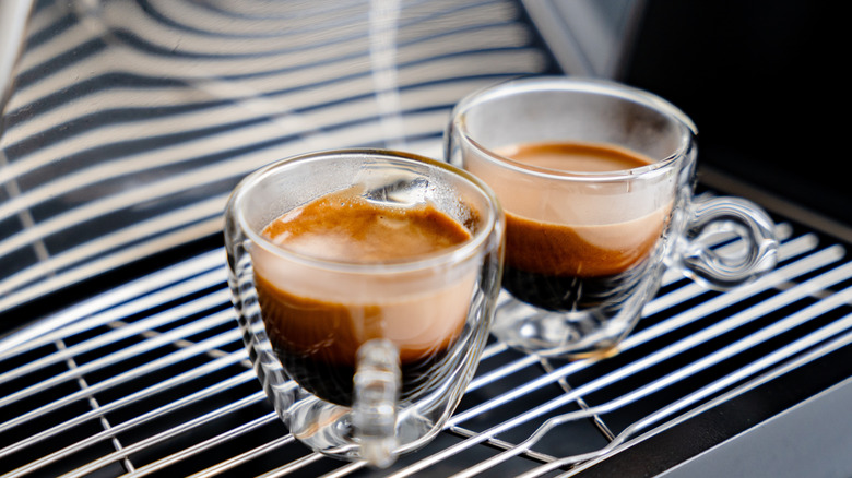 two shots of espresso under an espresso machine